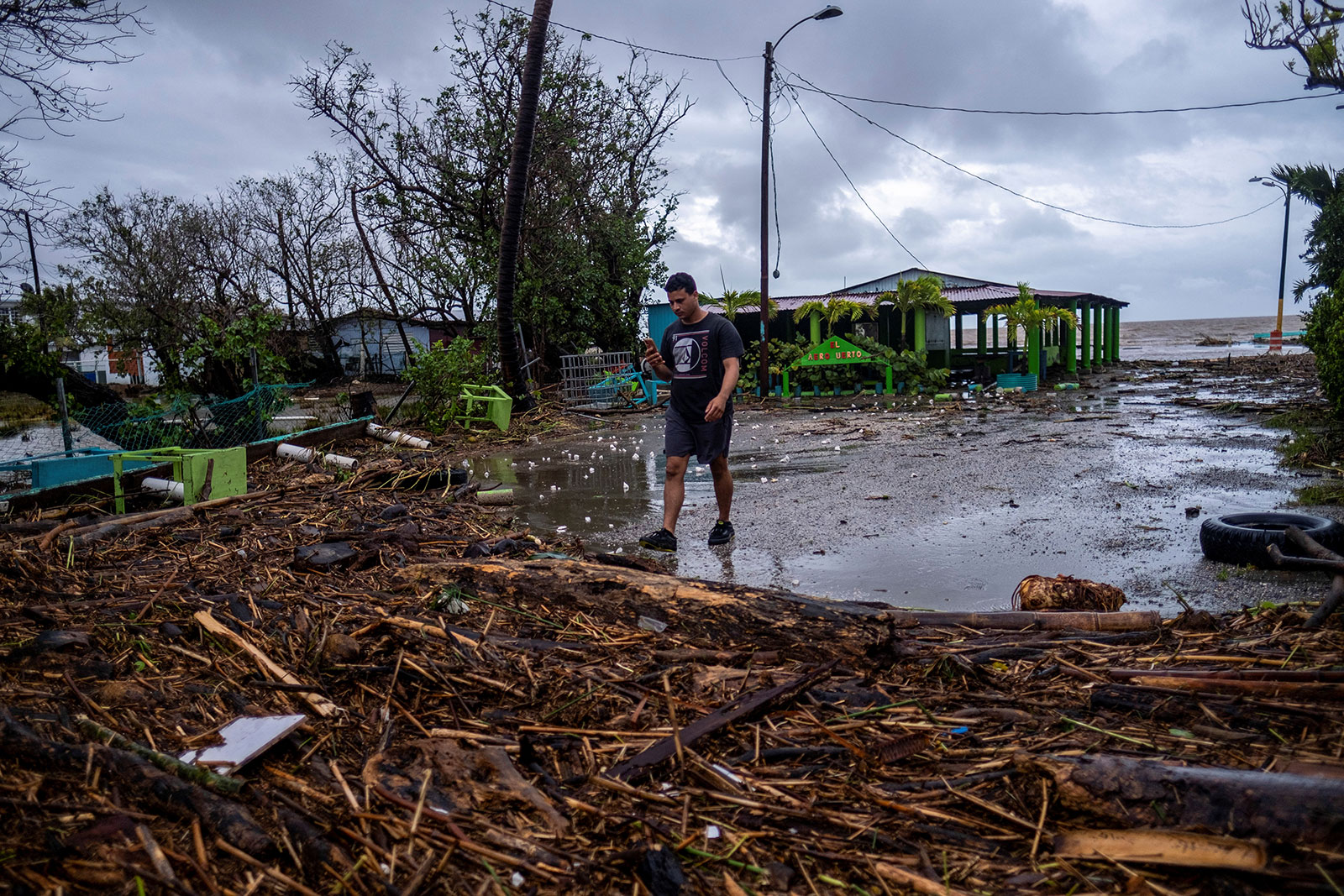A man walks through debris in the aftermath of Hurricane Fiona in Guayanilla, Puerto Rico September 19, 2022.  REUTERS/Ricardo Arduengo